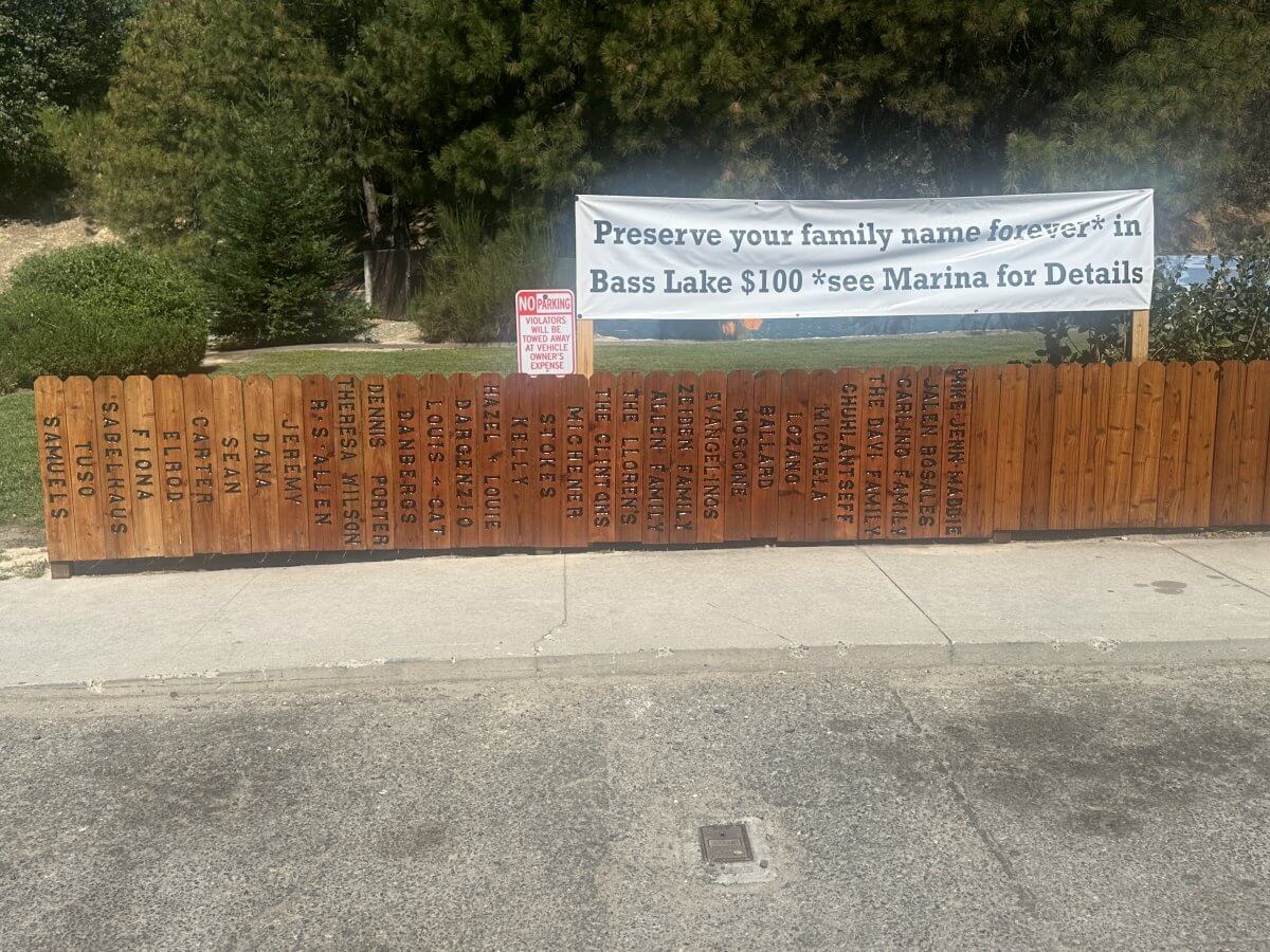 Bass Lake Memorial Fence Closeup Family Names on a Picket Fence Wider Angle