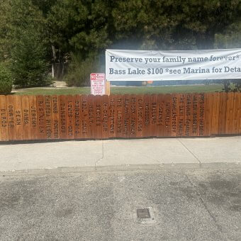 Bass Lake Memorial Fence Closeup Family Names on a Picket Fence Wider Angle